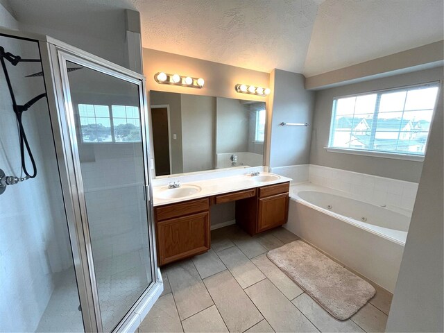 bathroom featuring a textured ceiling, vanity, and plus walk in shower