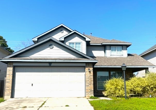 view of front of house with concrete driveway, an attached garage, and brick siding