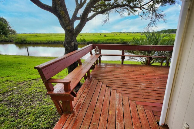 deck featuring a rural view, a yard, and a water view