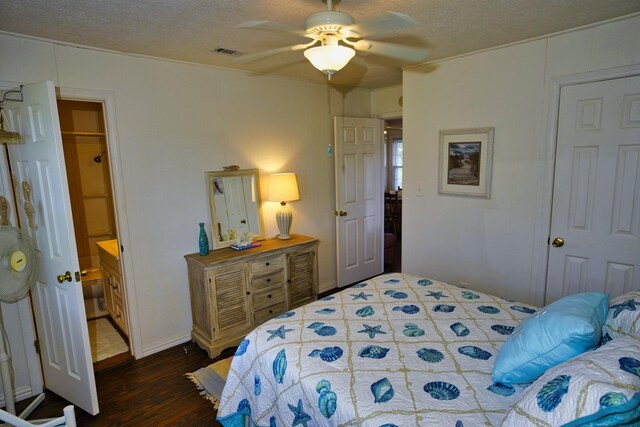 bedroom with a textured ceiling, connected bathroom, dark hardwood / wood-style floors, and ceiling fan