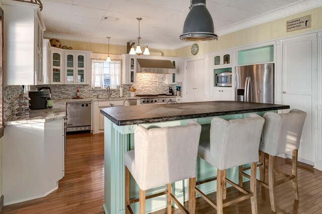 4850 County Road 328, Vanderbilt, TX 77969 - kitchen with range hood, stainless steel appliances, a kitchen island, dark wood finished floors, and a sink