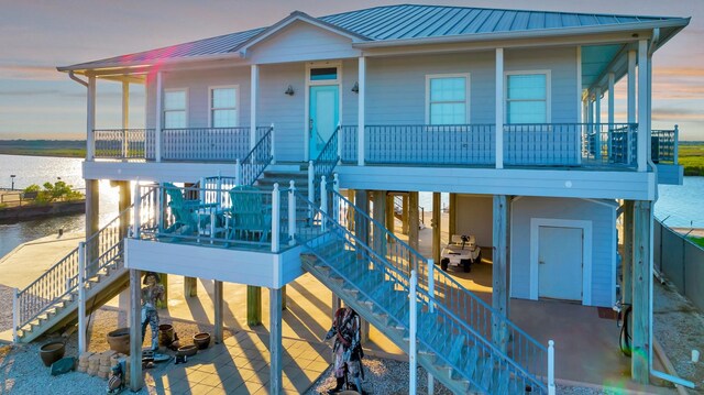 4850 County Road 328, Vanderbilt, TX 77969 - coastal inspired home with a water view, a standing seam roof, stairway, and metal roof