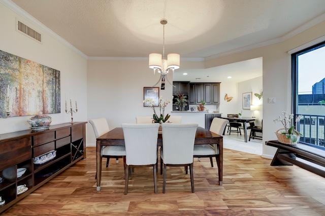 dining space with a chandelier, light wood-type flooring, a wealth of natural light, and ornamental molding