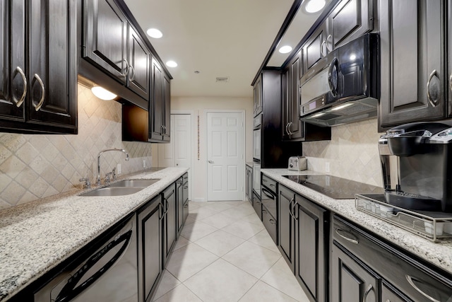 kitchen featuring black appliances, light stone countertops, and sink