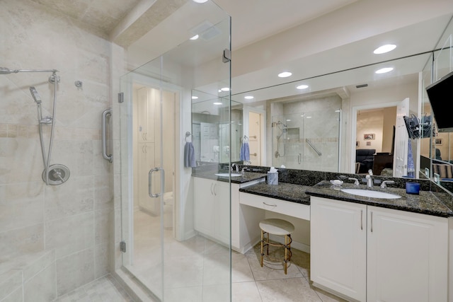 bathroom with walk in shower, vanity, and tile patterned floors