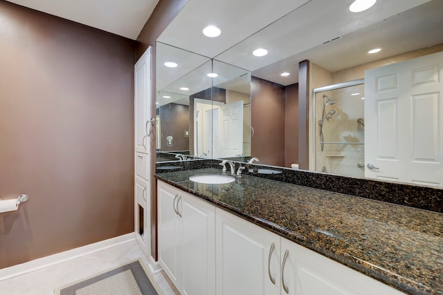 bathroom featuring walk in shower, vanity, and tile patterned floors