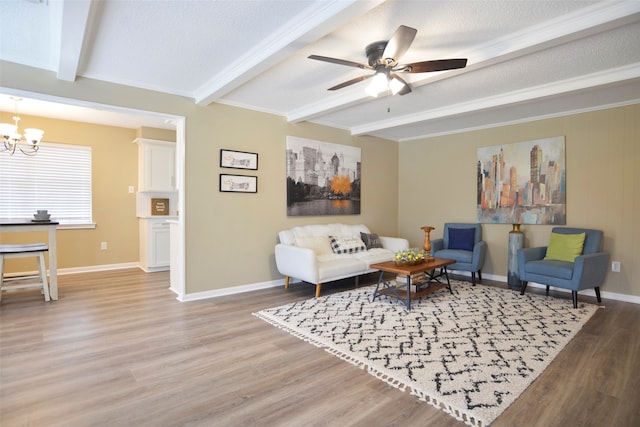 living room featuring ceiling fan with notable chandelier, wood-type flooring, a textured ceiling, and beam ceiling