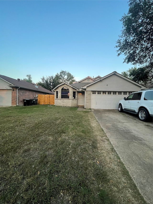 single story home featuring a garage and a front lawn