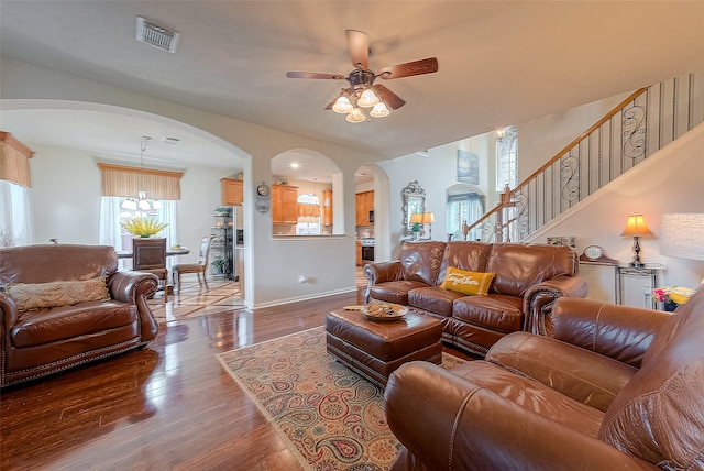 living room featuring ceiling fan with notable chandelier and hardwood / wood-style floors