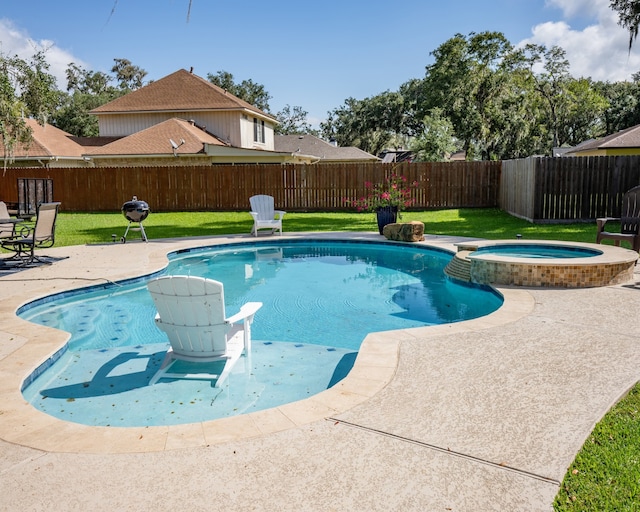 view of pool with a lawn, a patio area, and an in ground hot tub