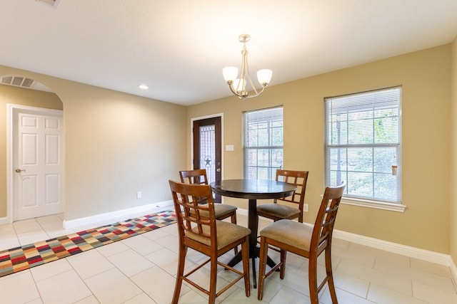 dining area with a chandelier and light tile patterned flooring