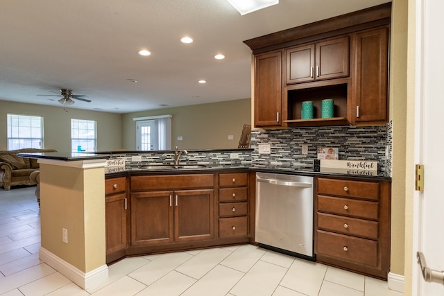 kitchen featuring kitchen peninsula, ceiling fan, backsplash, stainless steel dishwasher, and sink