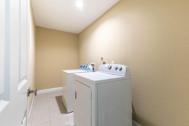 laundry room with washing machine and dryer and light tile patterned floors