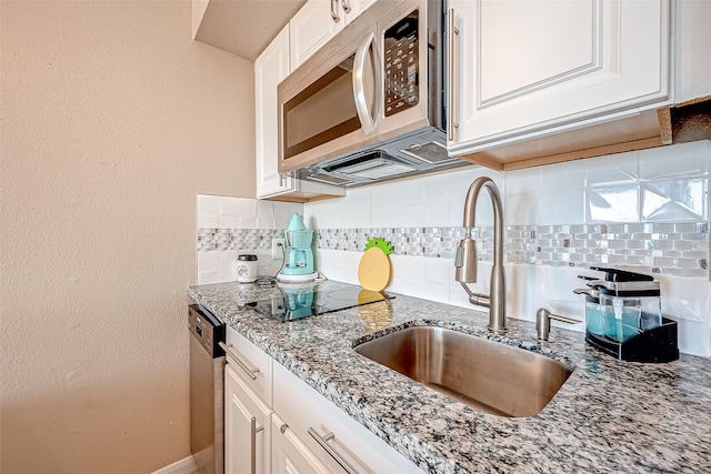 kitchen featuring white cabinets, stainless steel appliances, backsplash, and sink