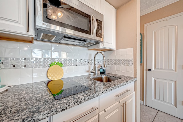 kitchen featuring white cabinetry, backsplash, light tile patterned floors, ceiling fan, and sink