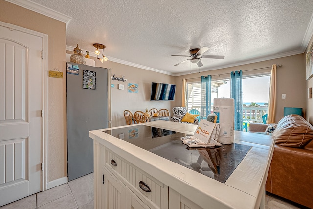 kitchen with ceiling fan, white cabinets, a textured ceiling, and crown molding