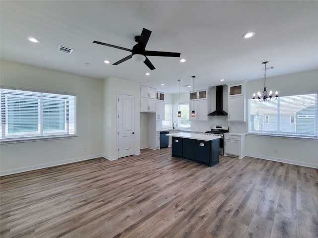 kitchen featuring ceiling fan with notable chandelier, plenty of natural light, and white cabinetry