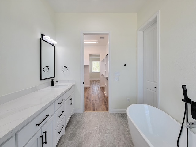 bathroom with vanity, a tub to relax in, and hardwood / wood-style flooring