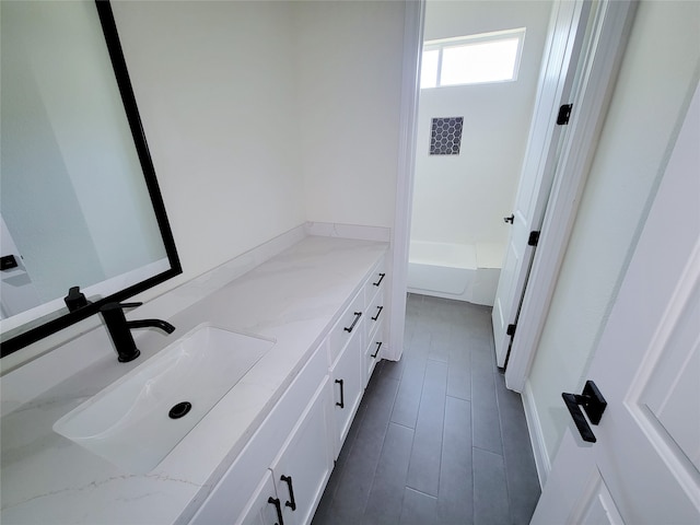 bathroom with vanity and a tub