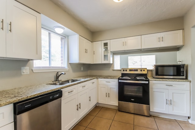 kitchen with a healthy amount of sunlight, white cabinetry, sink, and stainless steel appliances