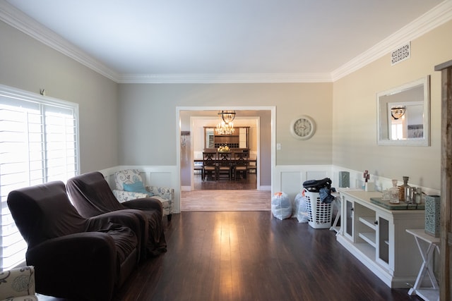 living room featuring an inviting chandelier, crown molding, and dark hardwood / wood-style flooring