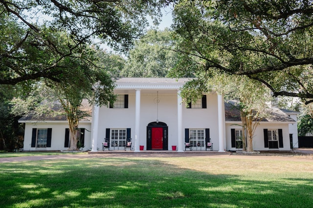 neoclassical home featuring a front yard