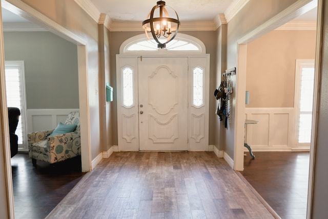 entryway featuring ornamental molding, dark hardwood / wood-style flooring, and a notable chandelier