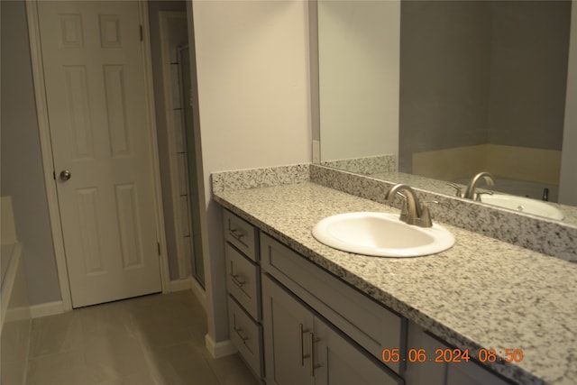 bathroom featuring vanity, tile patterned flooring, and a washtub