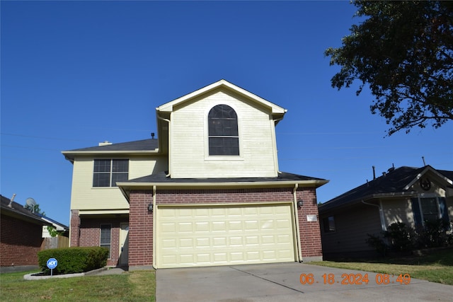 traditional-style house with an attached garage, brick siding, and driveway