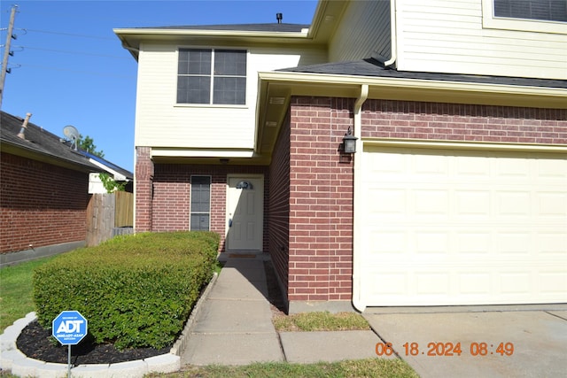 entrance to property featuring brick siding and a garage