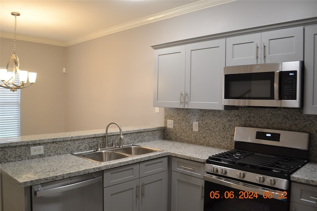 kitchen featuring hanging light fixtures, sink, a chandelier, appliances with stainless steel finishes, and crown molding