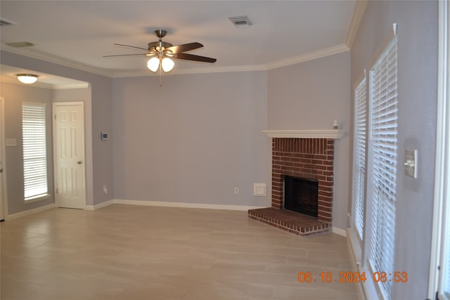 unfurnished living room with crown molding, ceiling fan, and a brick fireplace