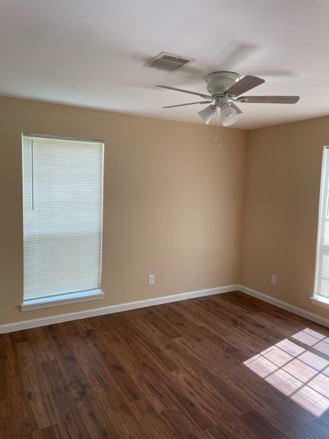 spare room with dark hardwood / wood-style flooring and ceiling fan