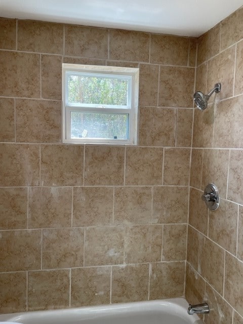 bathroom featuring tiled shower / bath