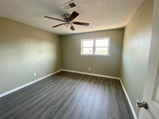 spare room with ceiling fan, dark wood-type flooring, and a textured ceiling