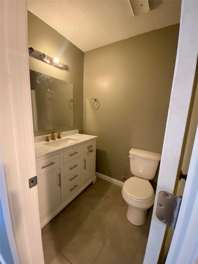 8922 Glacier Ave, Texas City, TX 77591 - bathroom with tile patterned floors, toilet, vanity, a textured ceiling, and baseboards