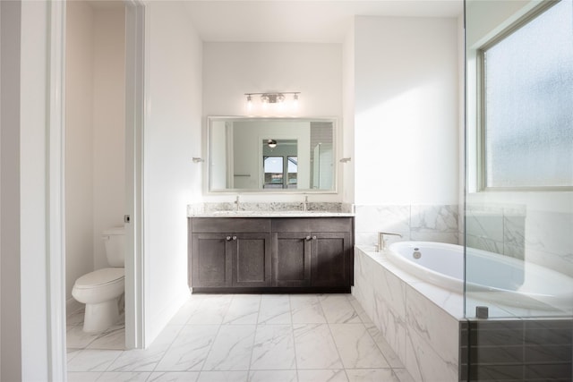 full bathroom with a garden tub, toilet, marble finish floor, and plenty of natural light