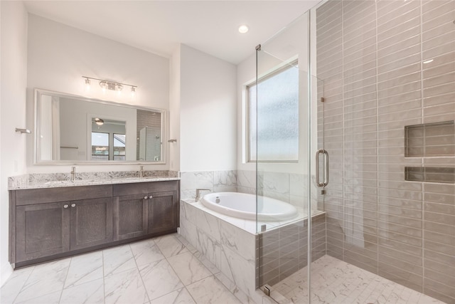 full bath with a garden tub, marble finish floor, a sink, a shower stall, and double vanity