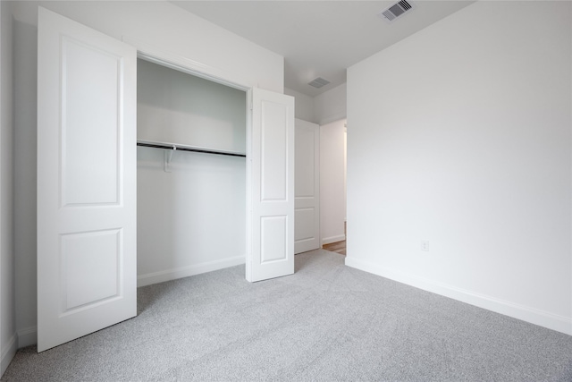 unfurnished bedroom with visible vents, carpet floors, baseboards, and a closet