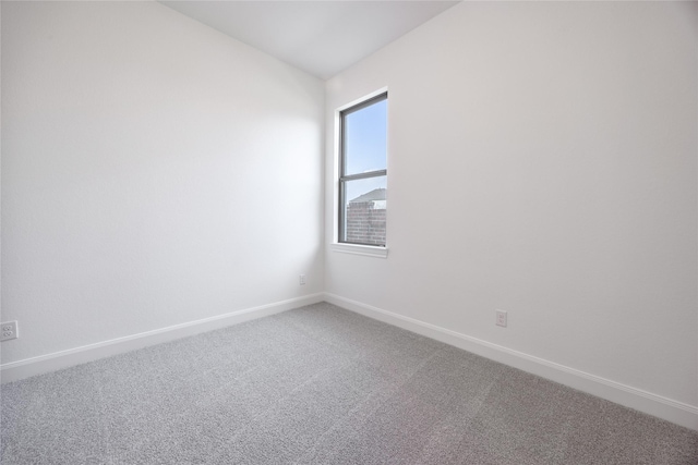 carpeted empty room featuring baseboards