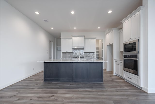 kitchen with visible vents, a sink, tasteful backsplash, stainless steel appliances, and white cabinets