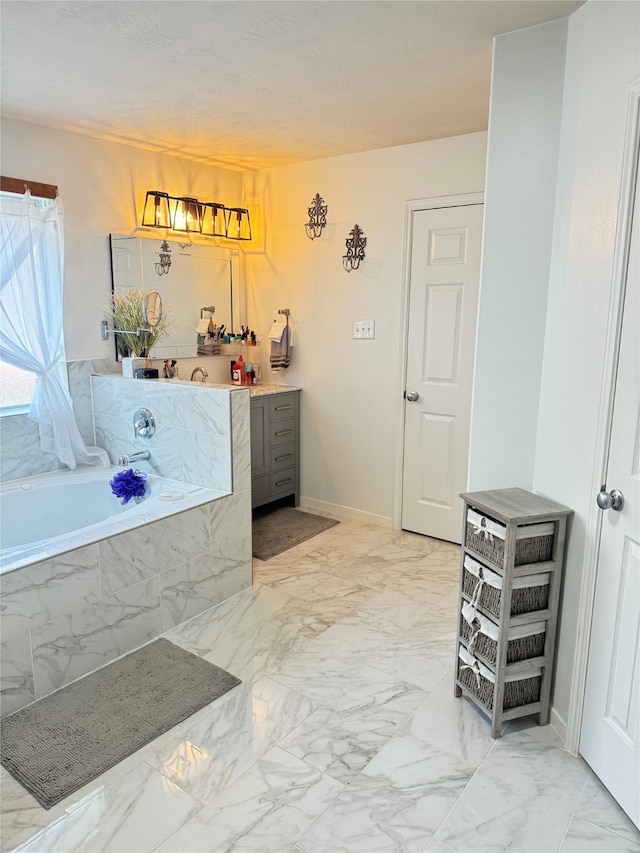 bathroom featuring tiled tub and vanity