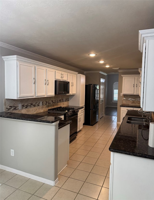 kitchen with white cabinets, dark stone counters, backsplash, and black appliances