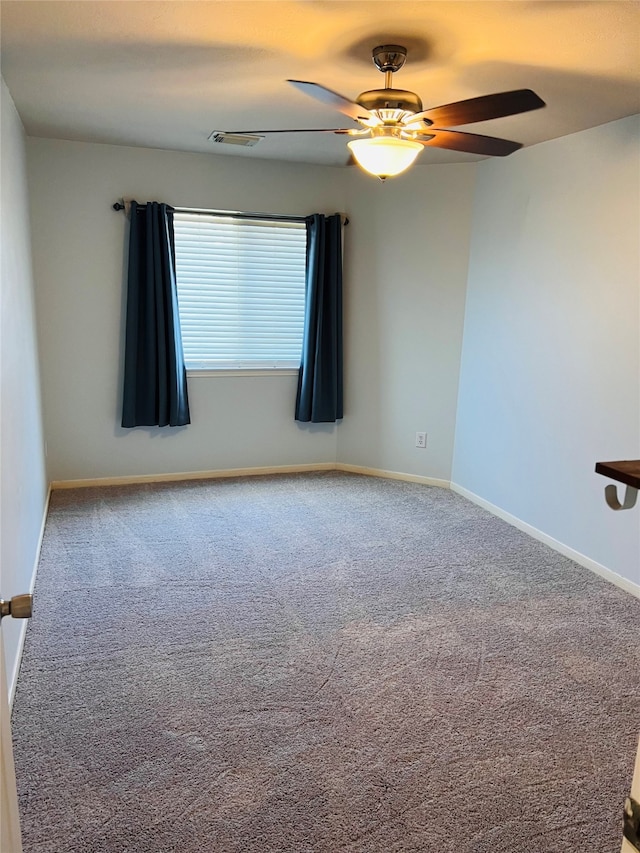 spare room with ceiling fan and carpet