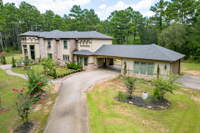 view of front facade with a front lawn and a carport