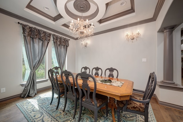 dining space featuring ornate columns, coffered ceiling, an inviting chandelier, crown molding, and hardwood / wood-style floors