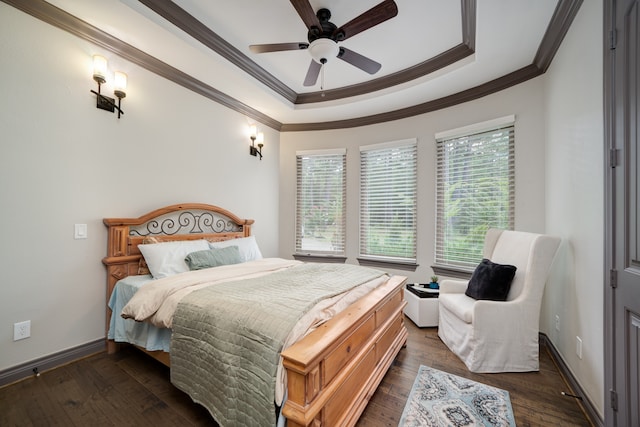 bedroom featuring ceiling fan, a raised ceiling, crown molding, and dark wood-type flooring