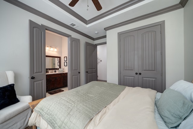 bedroom featuring a closet, ceiling fan, ensuite bathroom, and crown molding