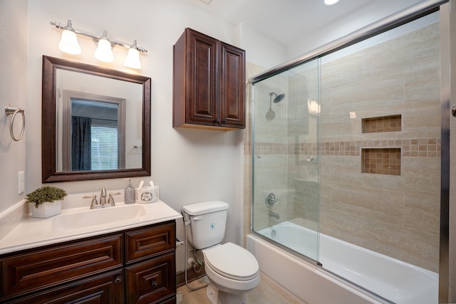 full bathroom with bath / shower combo with glass door, vanity, and toilet