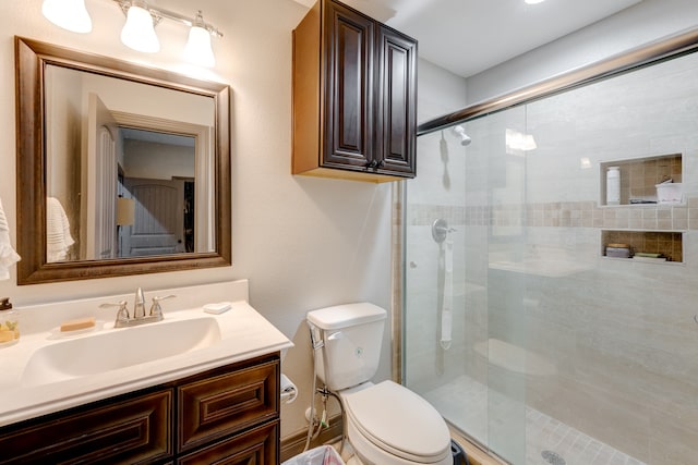 bathroom featuring vanity, toilet, and an enclosed shower